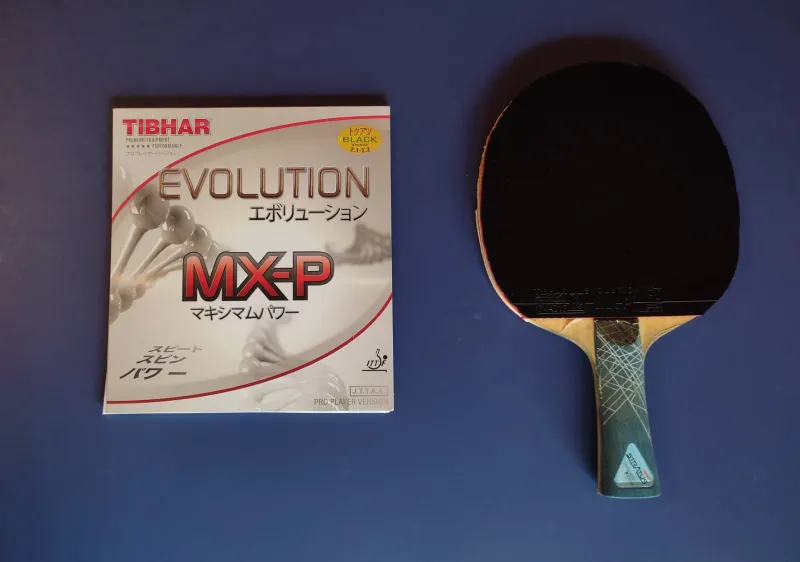 A picture of the Tibhar Evolution MX-P Package and on a racket